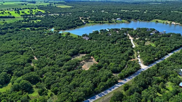 an aerial view of residential houses with outdoor space and trees