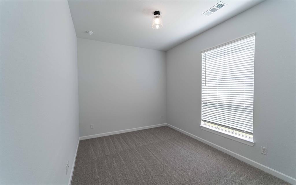 2008 Casting Ridge Mesquite, TX 75181 - Photo 2 of 24 Neutral-toned room featuring light gray walls, dark gray patterned carpeting, a single window with white blinds, white baseboards, and a ceiling-mounted light fixture