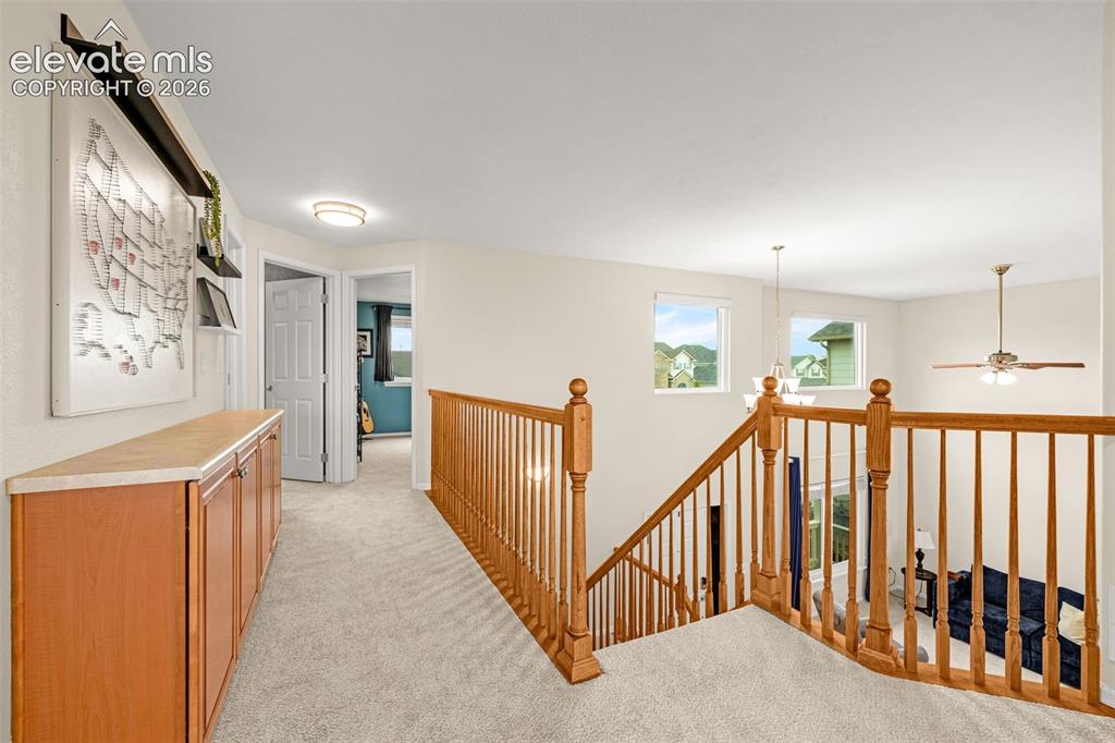9127 Oakmont Road Peyton, CO 80831 - Photo 26 of 49 a view of a hallway with wooden floor and stairs