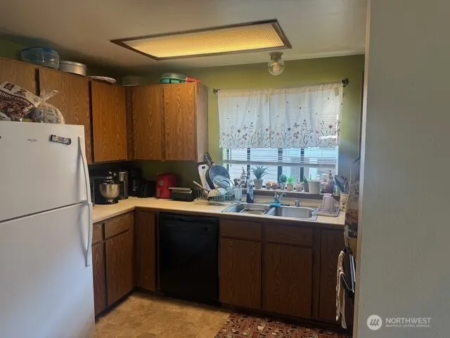 a kitchen with a sink a refrigerator and cabinets
