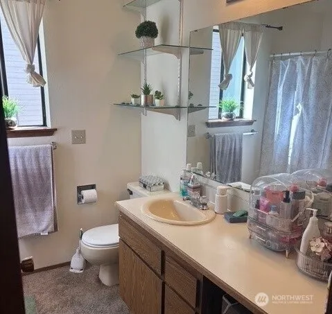 a bathroom with a sink vanity mirror and toilet