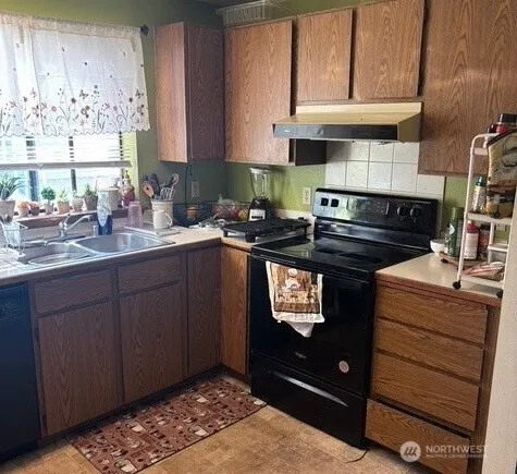 a kitchen with stainless steel appliances granite countertop a sink stove and cabinets