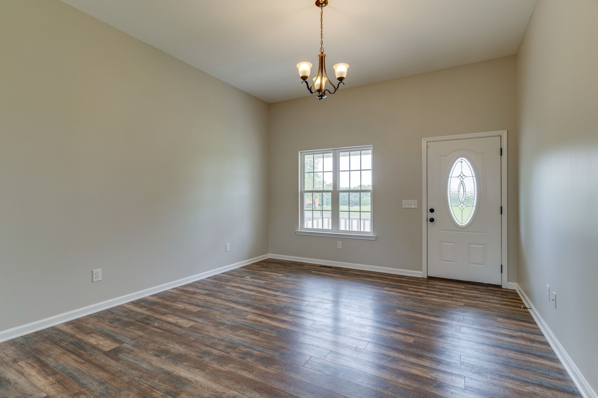 202 Shaub Road Portland, TN 37148 - Photo 4 of 25 an empty room with wooden floor chandelier and windows