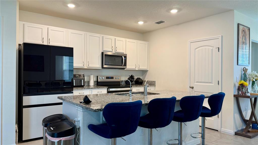 13340 Pontoon Road Winter Garden, FL 34787 - Photo 2 of 15 a kitchen with stainless steel appliances granite countertop a stove a sink a microwave a refrigerator and cabinets