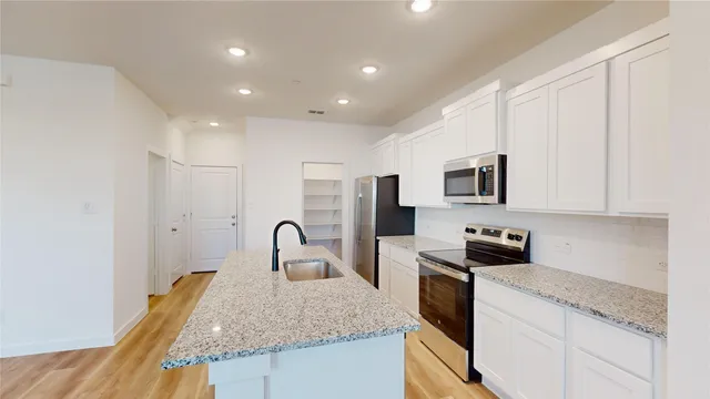 a kitchen with stainless steel appliances granite countertop a sink stove and microwave