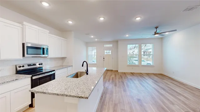 a kitchen with sink cabinets and wooden floor