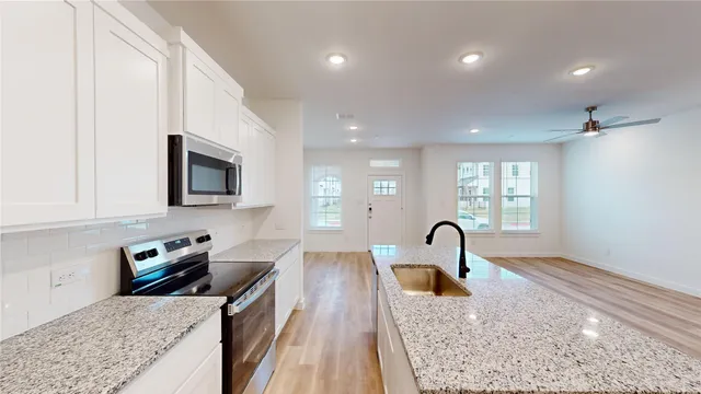 a kitchen with granite countertop a stove and a sink