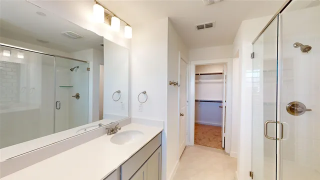 a bathroom with a shower sink vanity granite and shower