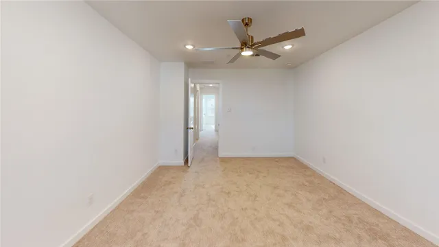 an empty room with a ceiling fan and a window