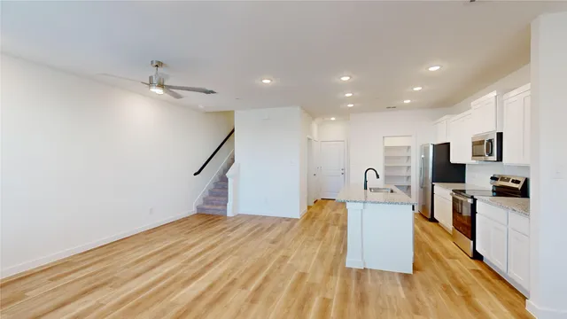 a view of a kitchen with cabinets and wooden floor