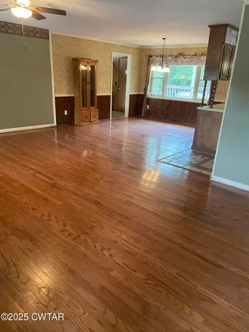 an empty room with wooden floor and entrance