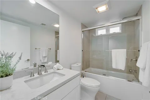 a bedroom with a balcony a bed and a potted plant on the dresser