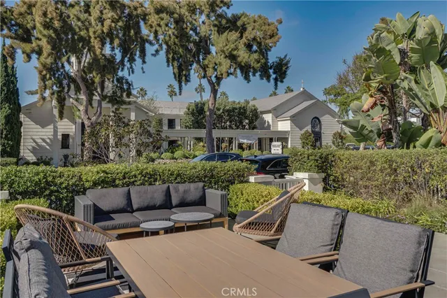 a view of a patio with couches chairs dining table and chairs with wooden floor