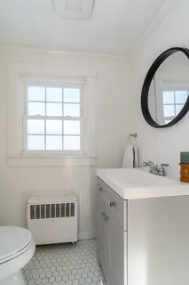 a bathroom with a sink a toilet and a mirror