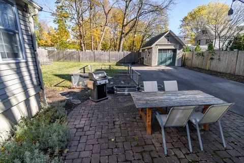 a view of a patio with table and chairs with wooden floor and fence