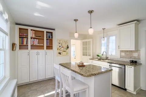 a kitchen with granite countertop a sink a stove and cabinets