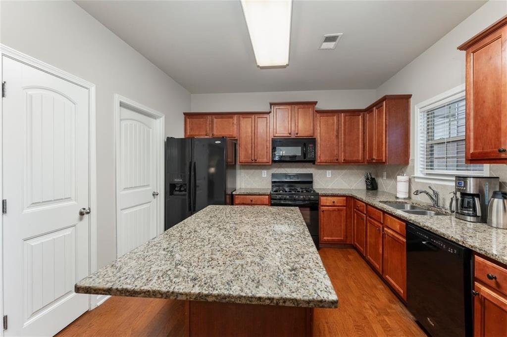 113 Tyson Woods Road Acworth, GA 30102 - Photo 14 of 37 a kitchen with stainless steel appliances granite countertop a stove refrigerator sink and cabinets