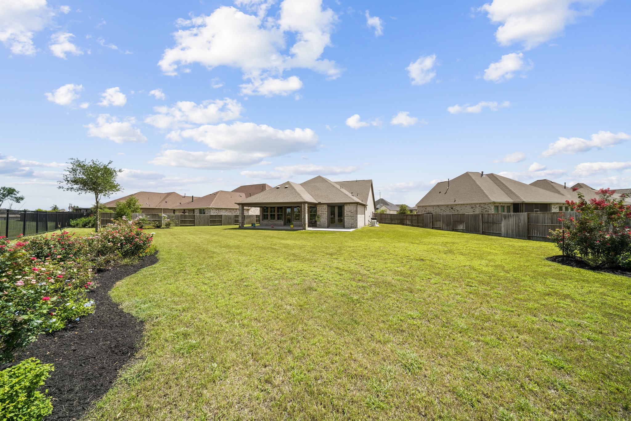 5739 Bobwhite Trail Manvel, TX 77578 - Photo 26 of 29 The expansive backyard offers endless possibilities for outdoor living, play, or future additions. Beautiful flowering landscape beds create a colorful, welcoming backdrop.