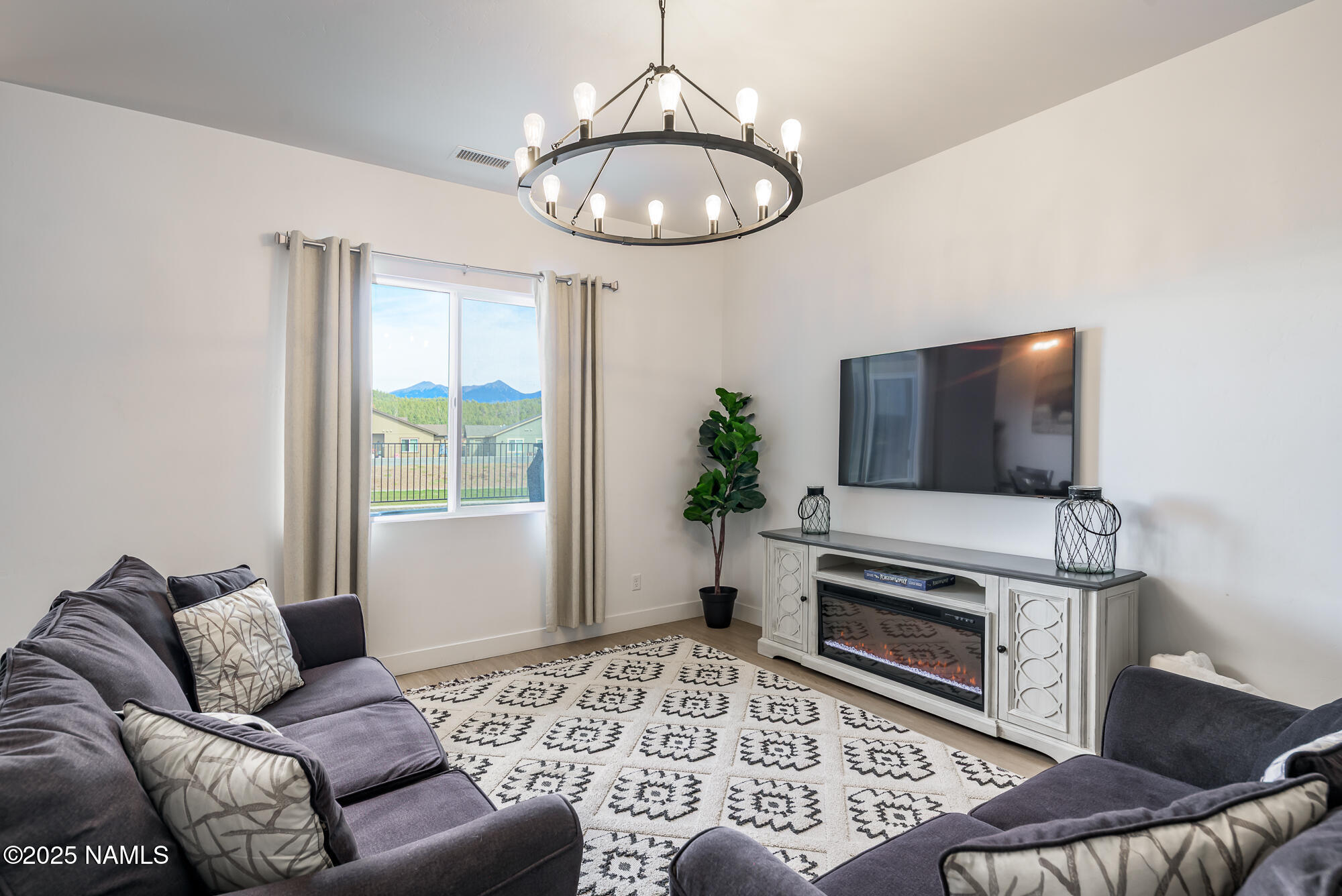 11780 Pegasus Road Bellemont, AZ 86015 - Photo 11 of 44 a living room with furniture a flat screen tv and a large window