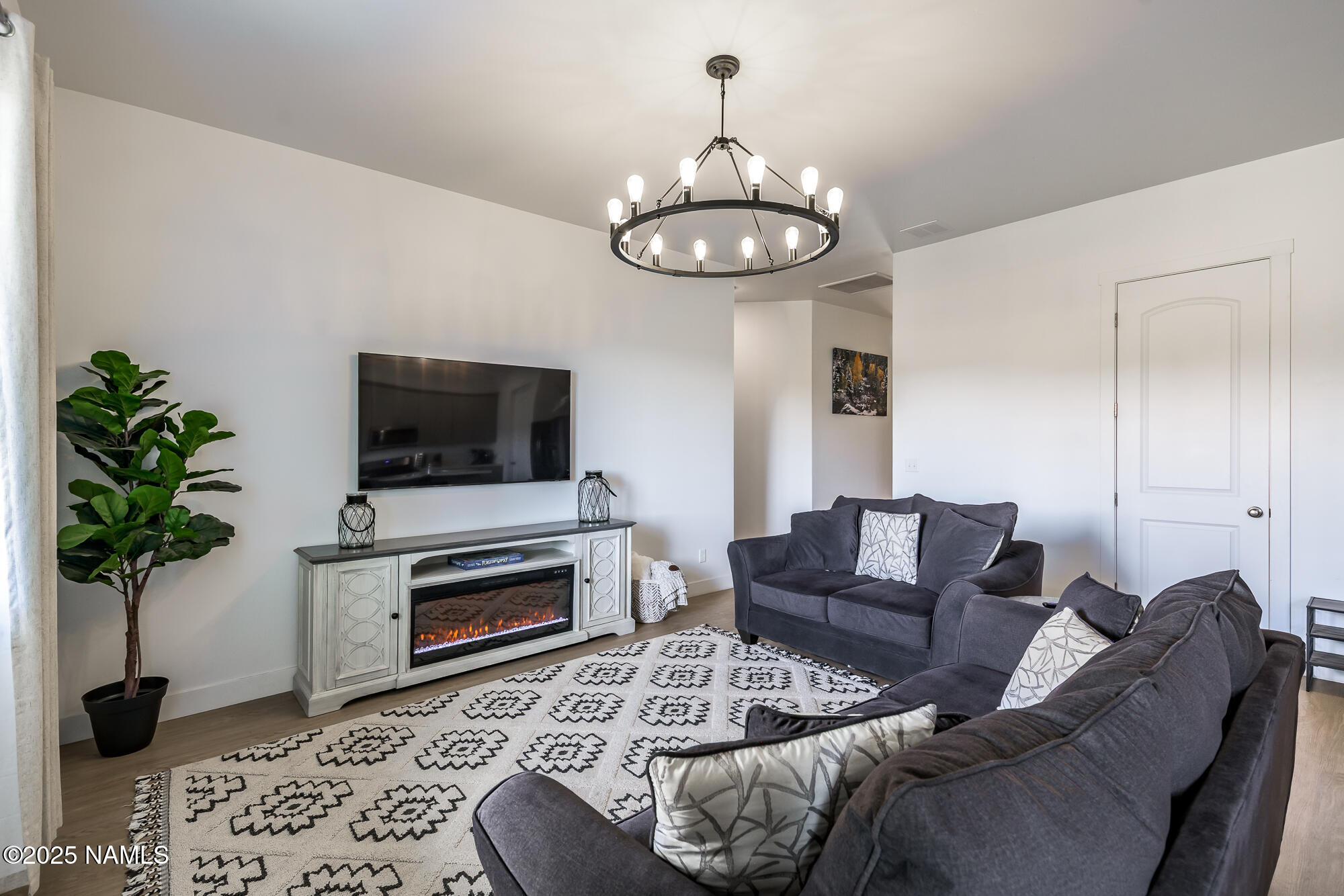 11780 Pegasus Road Bellemont, AZ 86015 - Photo 12 of 44 a living room with furniture a flat screen tv and a potted plant