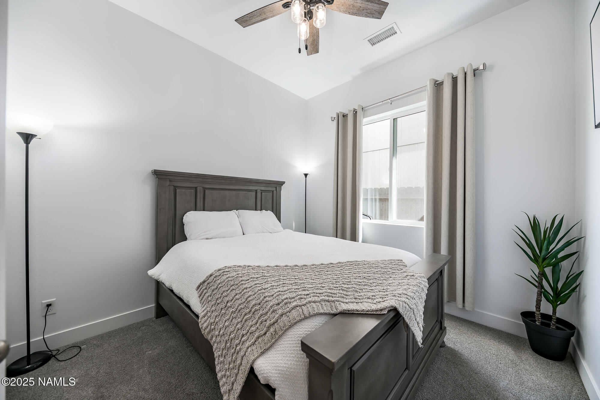 11780 Pegasus Road Bellemont, AZ 86015 - Photo 25 of 44 a bedroom with a large bed and a chandelier