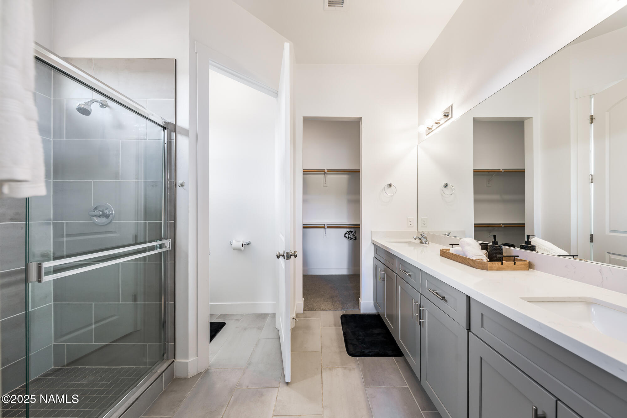 11780 Pegasus Road Bellemont, AZ 86015 - Photo 32 of 44 a spacious bathroom with a double vanity sink toilet mirror and shower