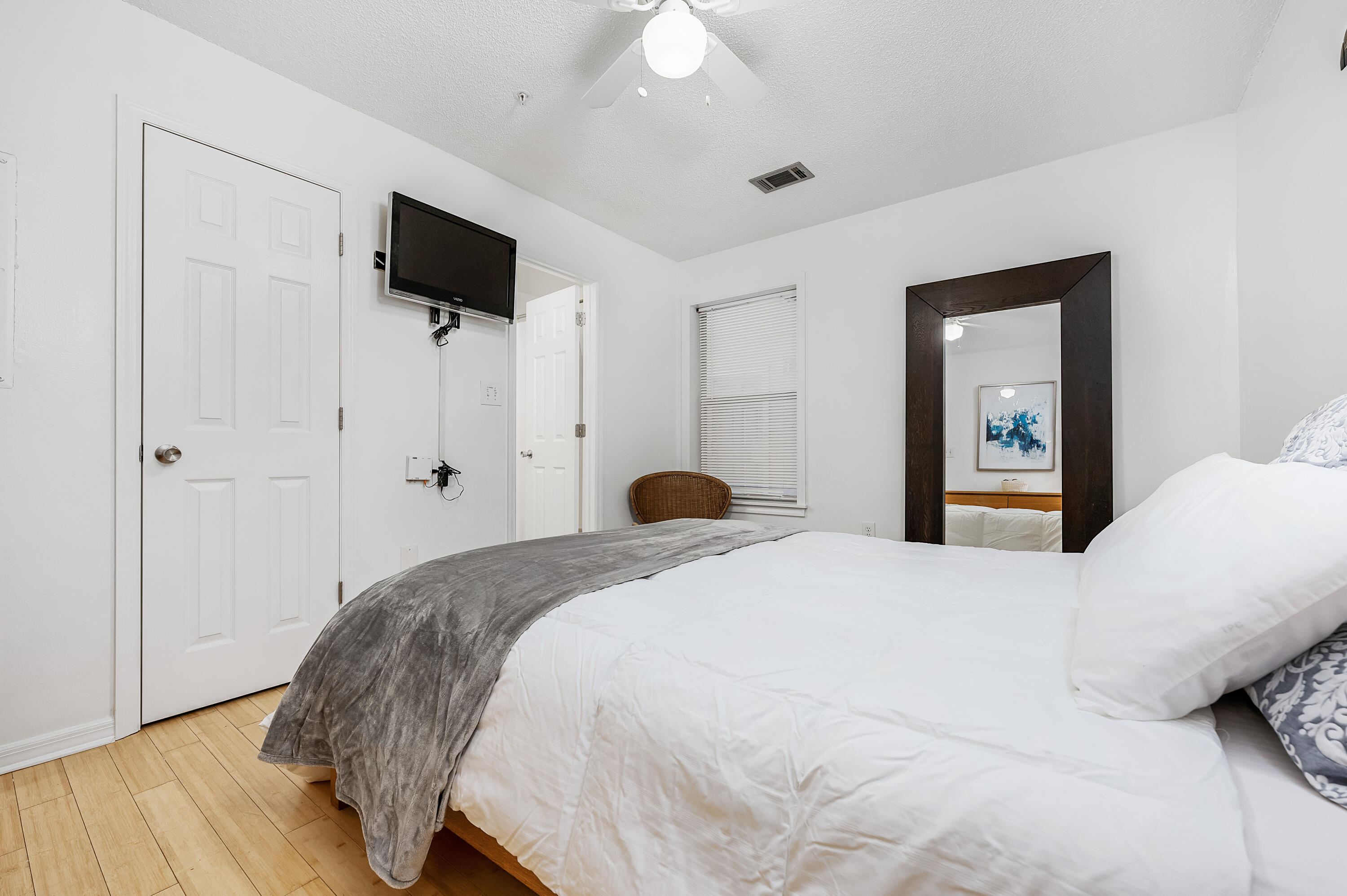 1006 E Highway, Unit 212 Destin, FL 32541 - Photo 13 of 52 a bedroom with a bed and a flat tv screen on dresser