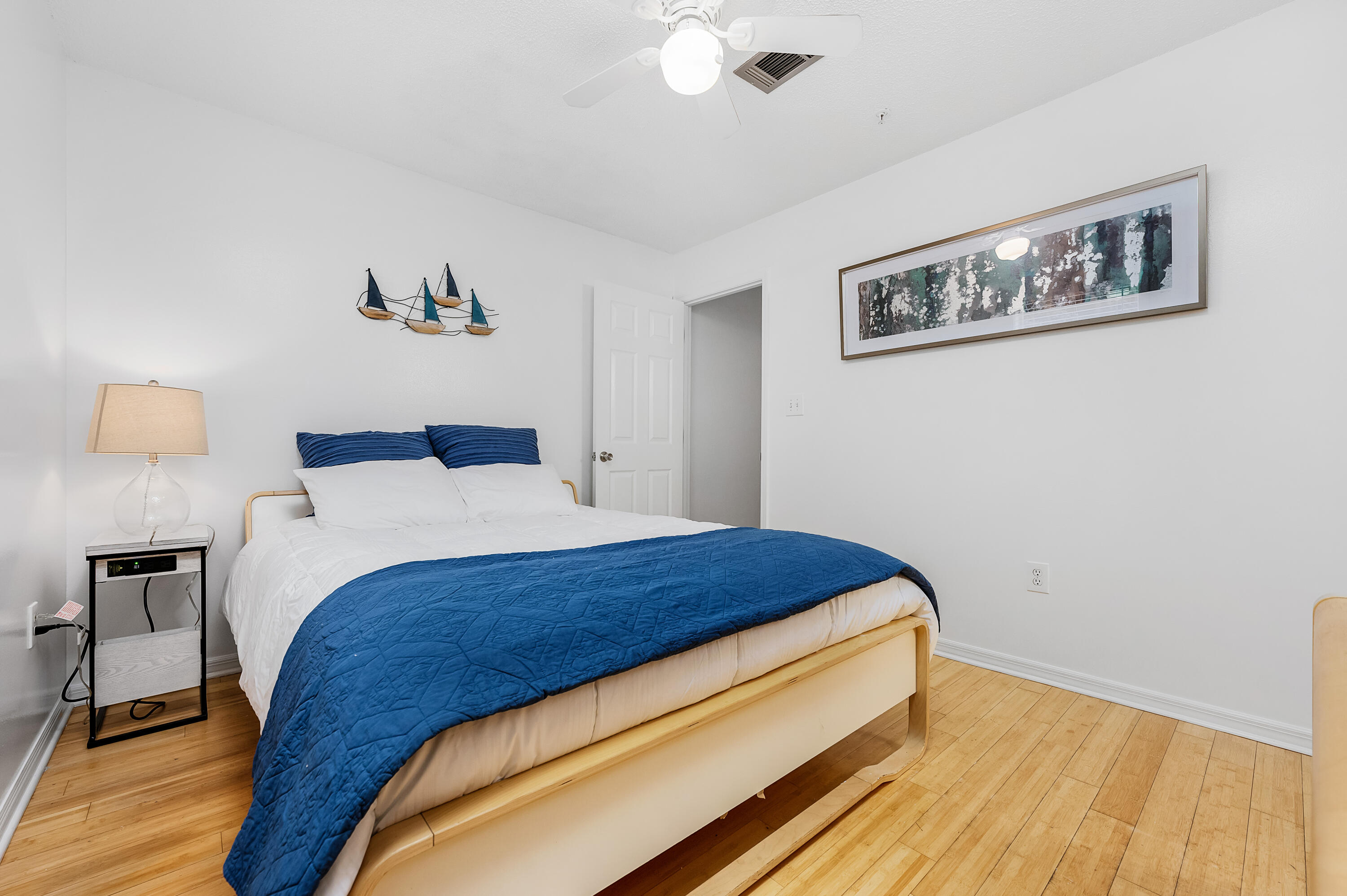 1006 E Highway, Unit 212 Destin, FL 32541 - Photo 22 of 52 a bedroom with bed and painting on the wall