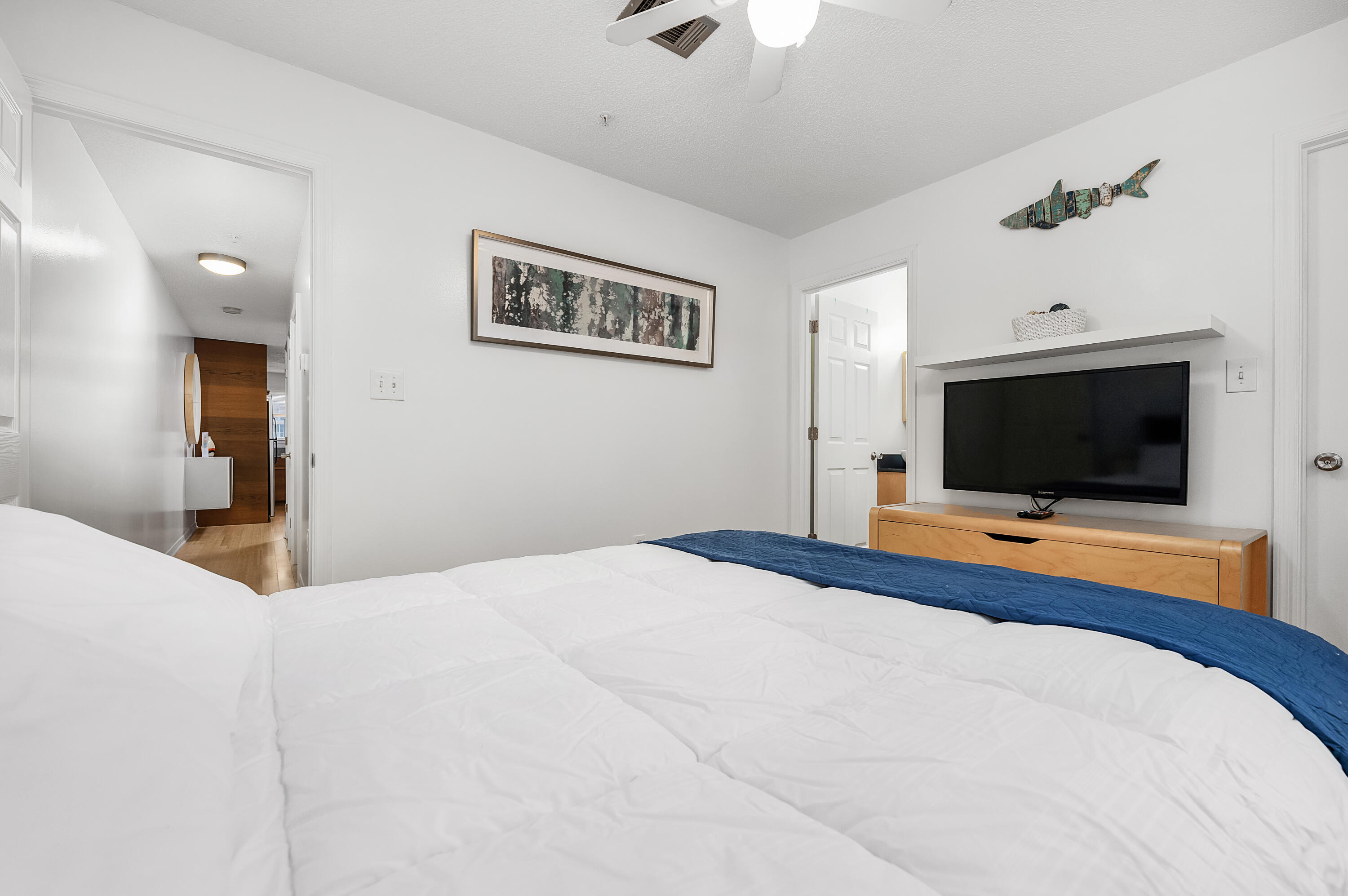 1006 E Highway, Unit 212 Destin, FL 32541 - Photo 23 of 52 a bedroom with a bed and a flat screen tv