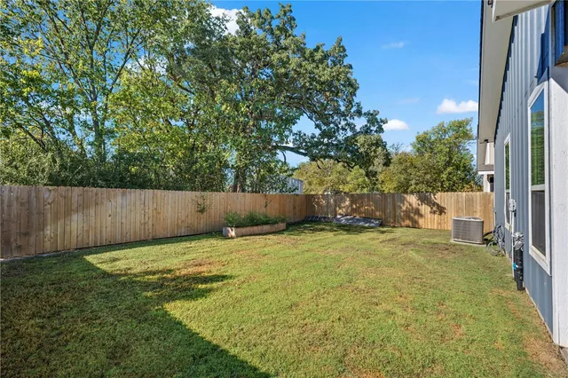 a backyard of a house with lots of plants and tree