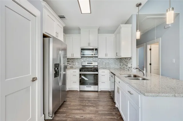 a kitchen with stainless steel appliances granite countertop a refrigerator and a sink