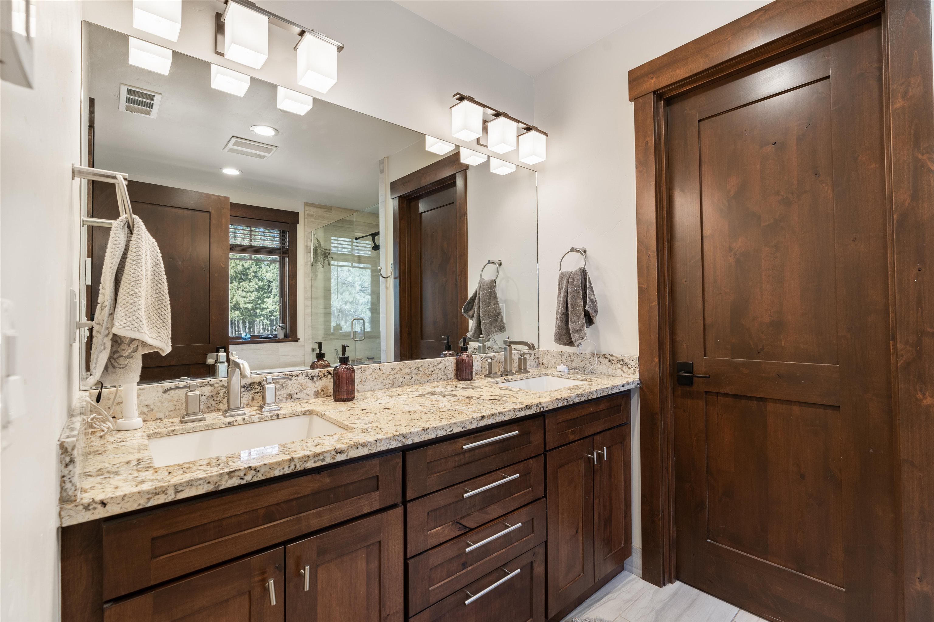 10237 Annies Loop, Unit A5 Truckee, CA 96161 - Photo 4 of 11 a bathroom with a granite countertop sink a large mirror and a shower