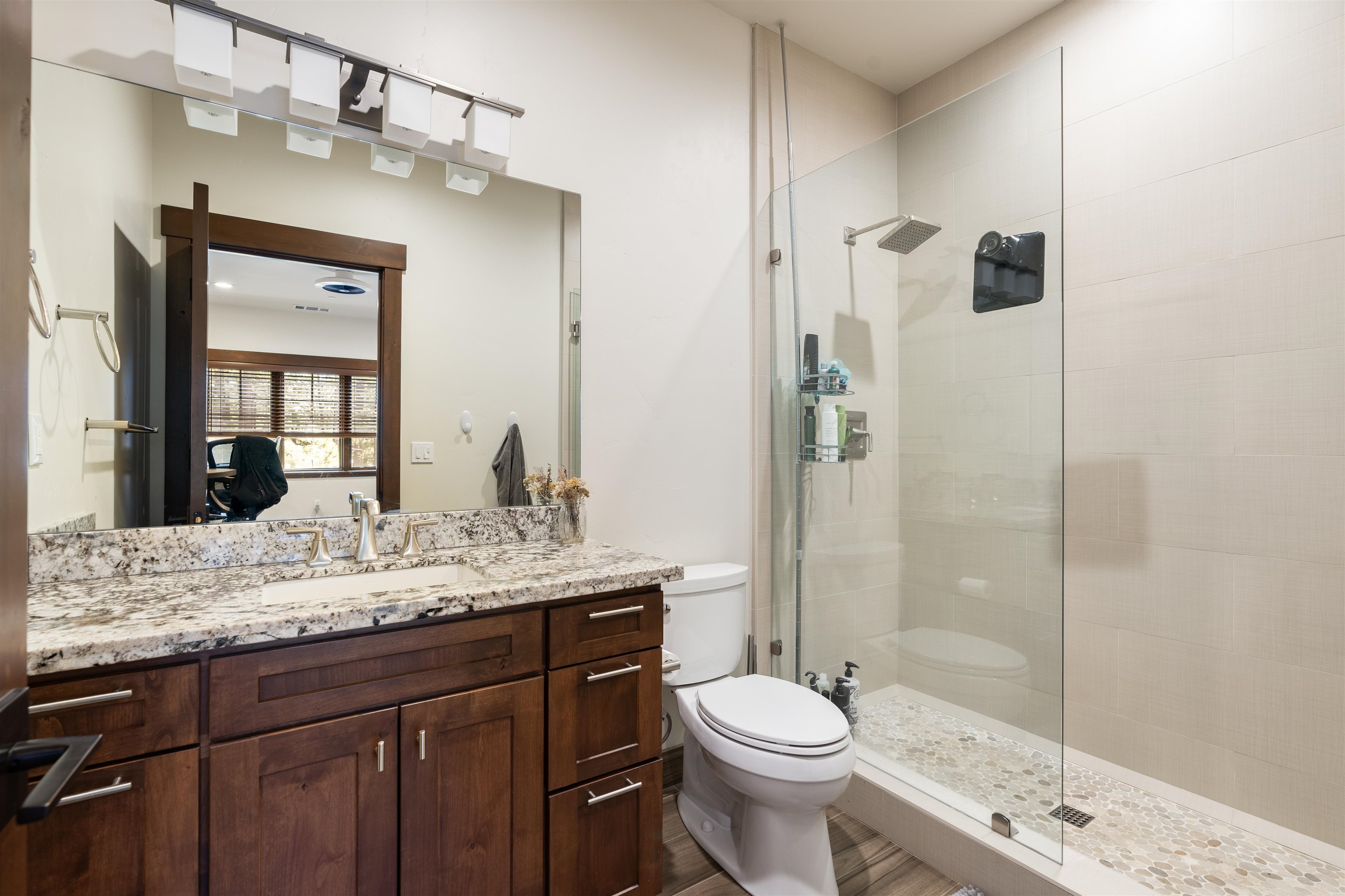 10237 Annies Loop, Unit A5 Truckee, CA 96161 - Photo 6 of 11 a bathroom with a granite countertop sink toilet mirror and shower