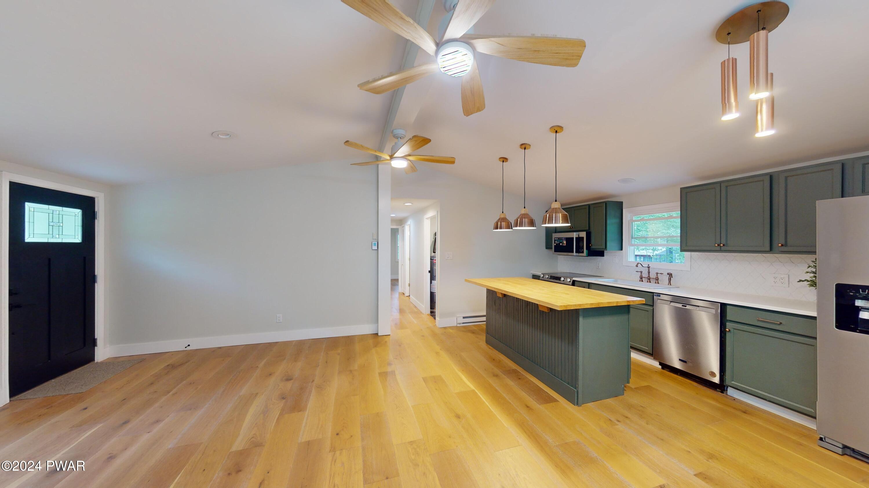 107 Hickory Road Milford, PA 18337 - Photo 29 of 39 a large kitchen with stainless steel appliances a sink dishwasher a refrigerator and white cabinets with wooden floor
