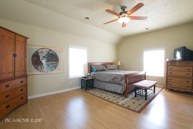 15063 Shabbona Road Malta, IL 60150 - Photo 15 of 25 a bedroom with a bed dresser and wooden floor