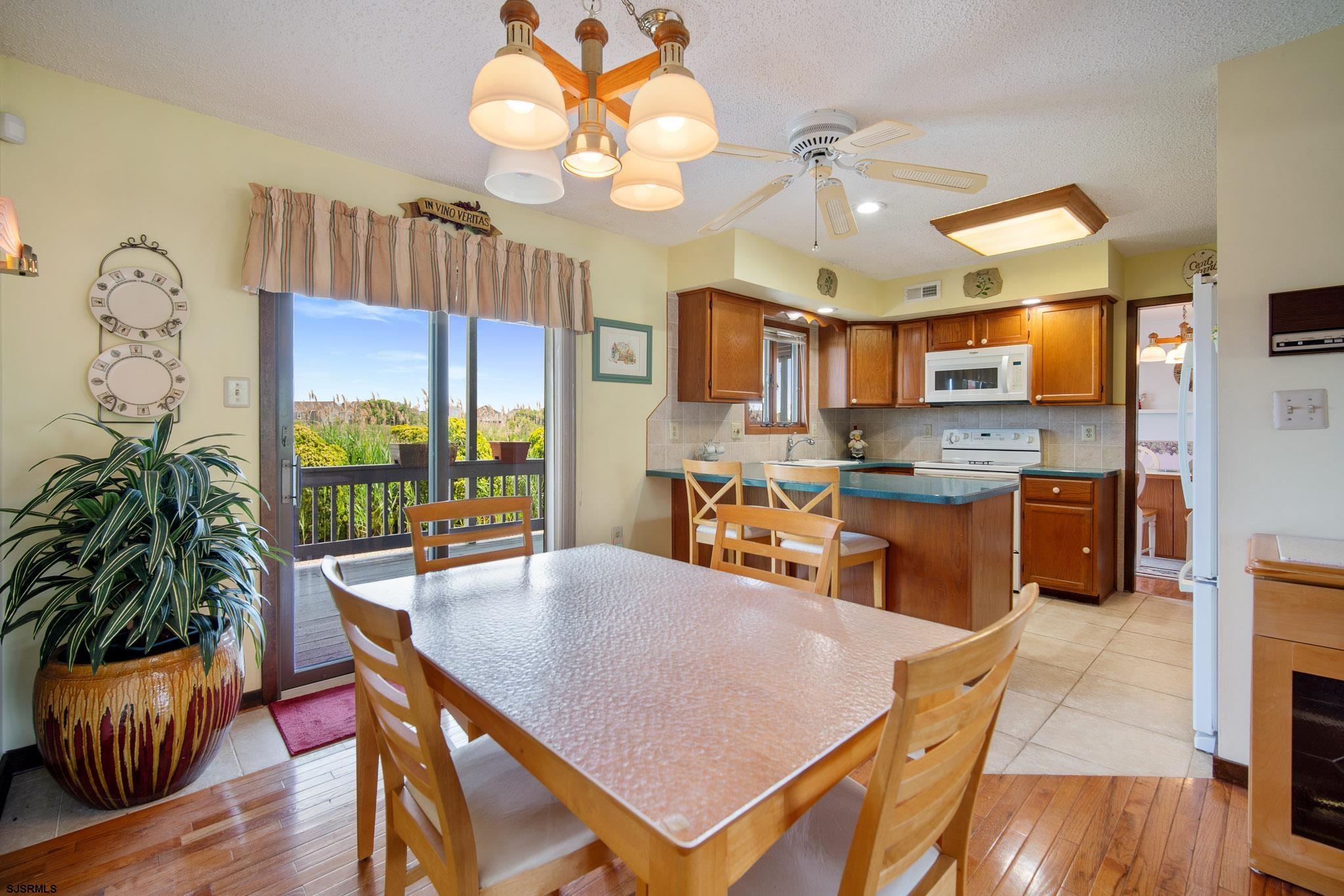 217 Hagen Road Brigantine, NJ 08203 - Photo 30 of 63 a view of a dining room with furniture a chandelier and wooden floor