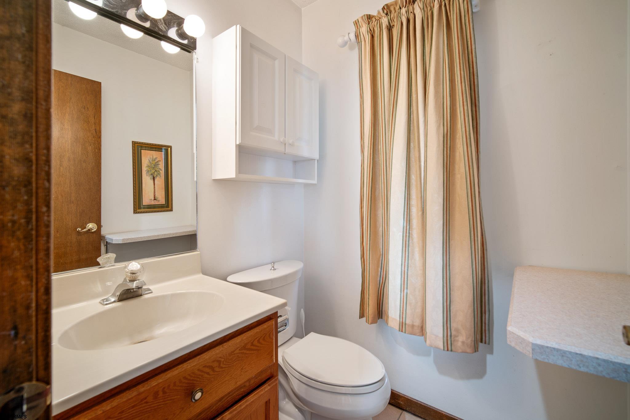 217 Hagen Road Brigantine, NJ 08203 - Photo 33 of 63 a bathroom with a sink a toilet and shower curtain