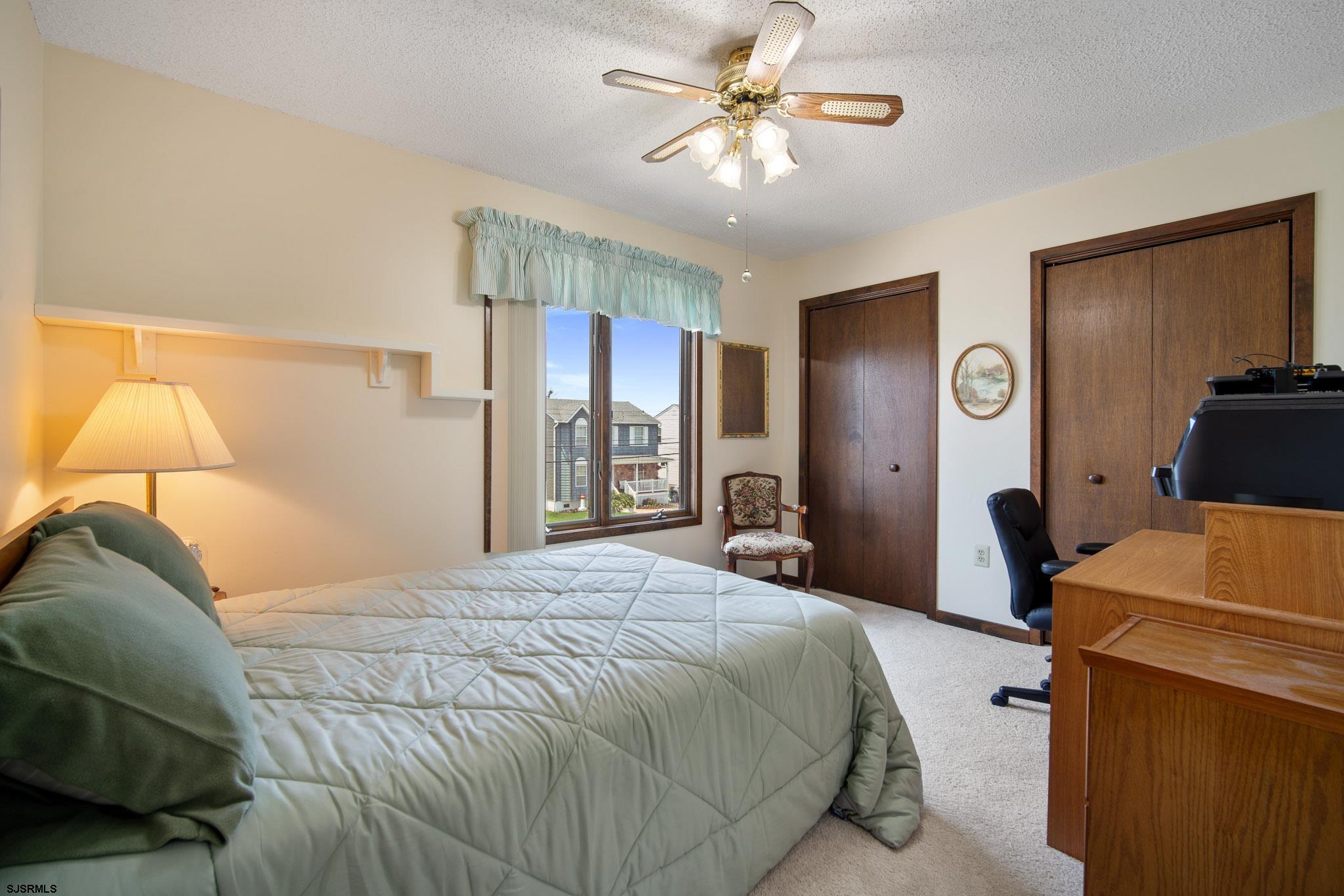 217 Hagen Road Brigantine, NJ 08203 - Photo 42 of 63 a bedroom with a bed and a chandelier