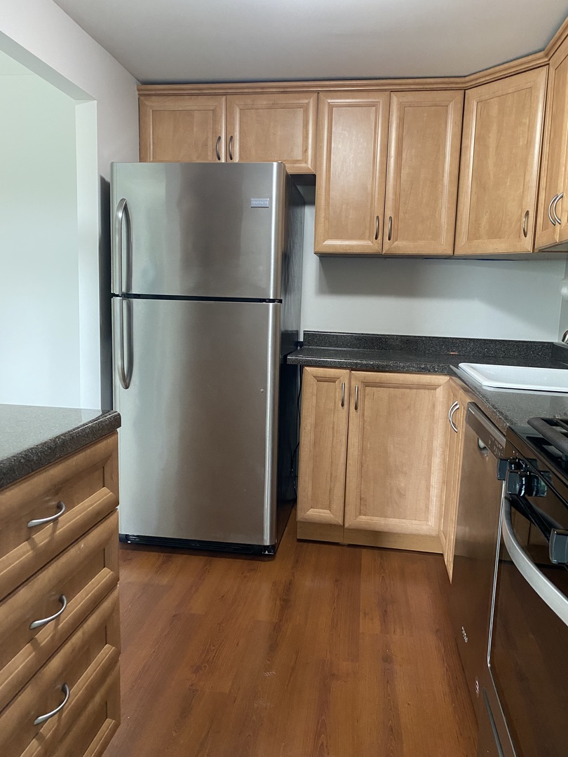 Undisclosed Address Schaumburg, IL 60193 - Photo 10 of 17 a view of a refrigerator in kitchen and an empty room with wooden floor