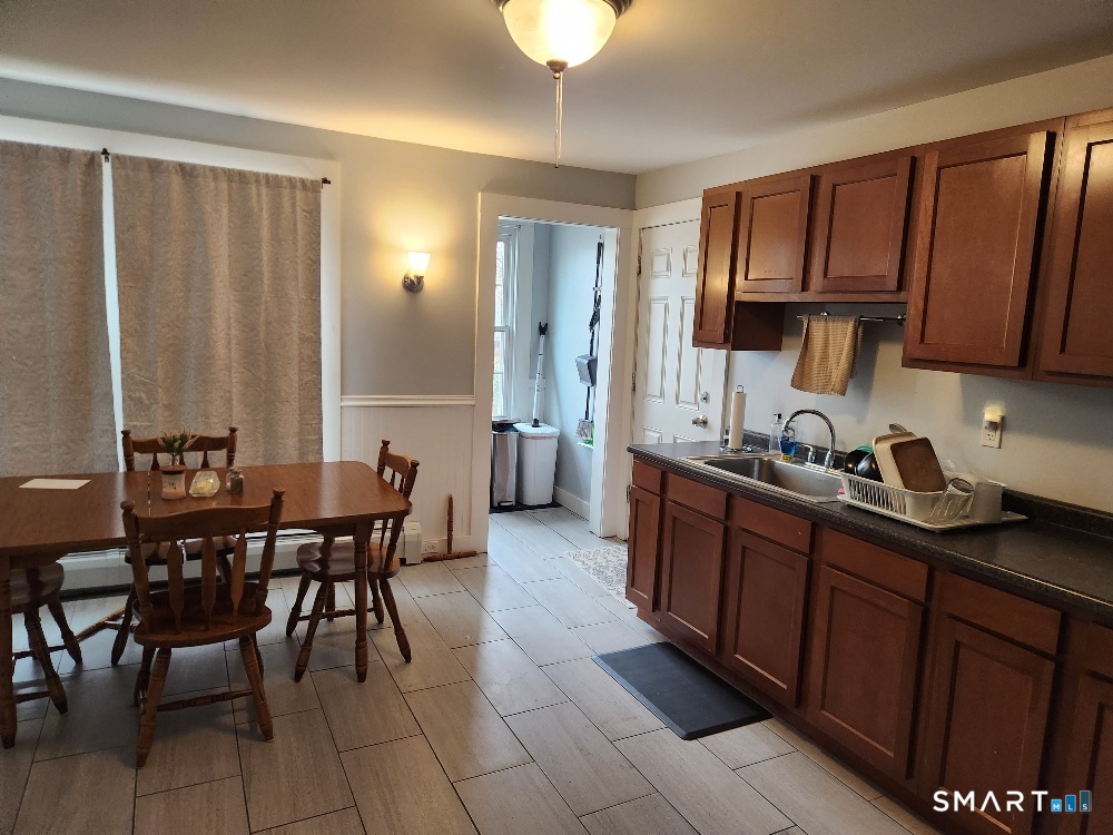 249 Church Street Windham, CT 06226 - Photo 6 of 10 a kitchen with stainless steel appliances granite countertop a sink a stove a dining table and chairs