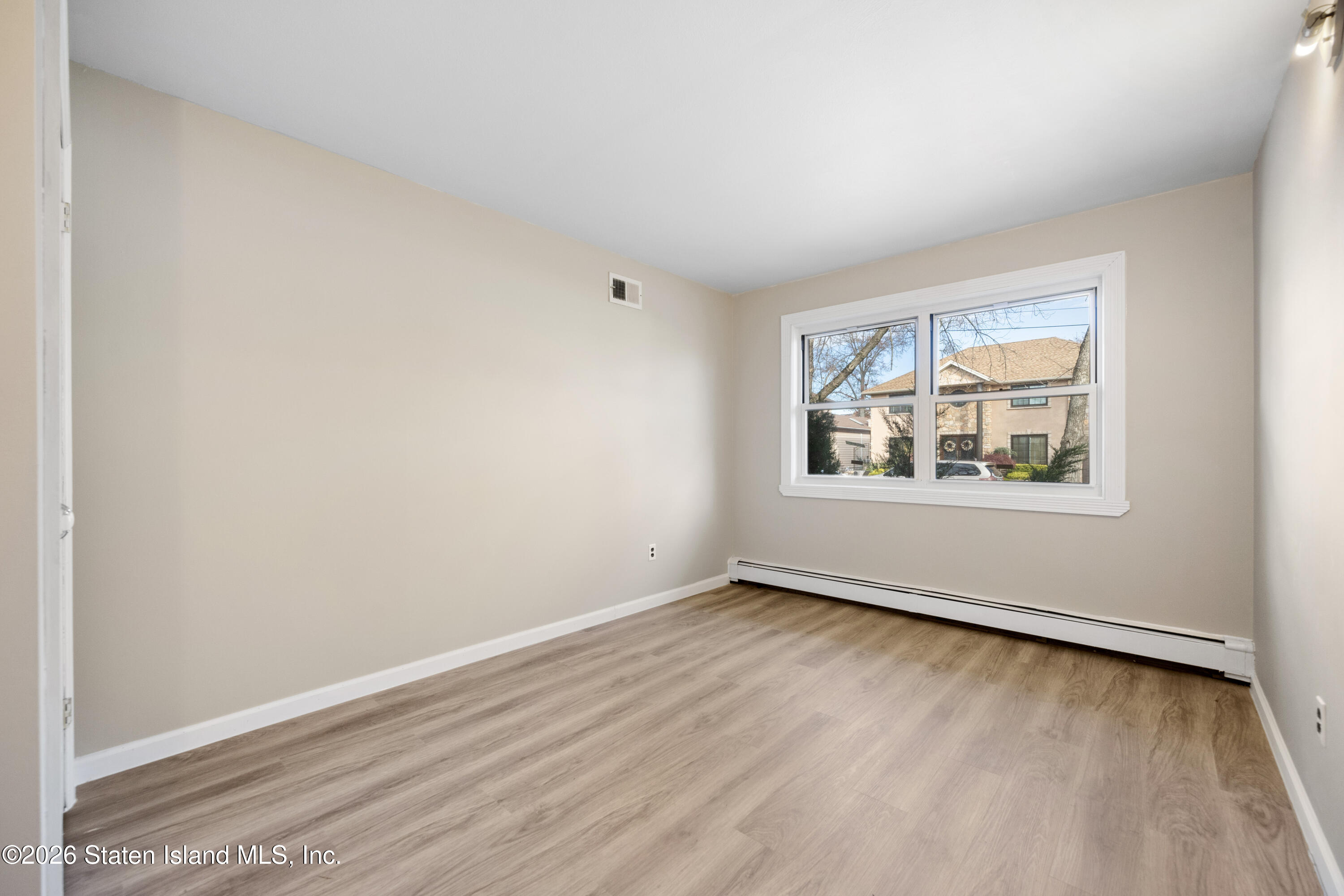 62 Bennett Place Staten Island, NY 10312 - Photo 12 of 34 an empty room with wooden floor and windows