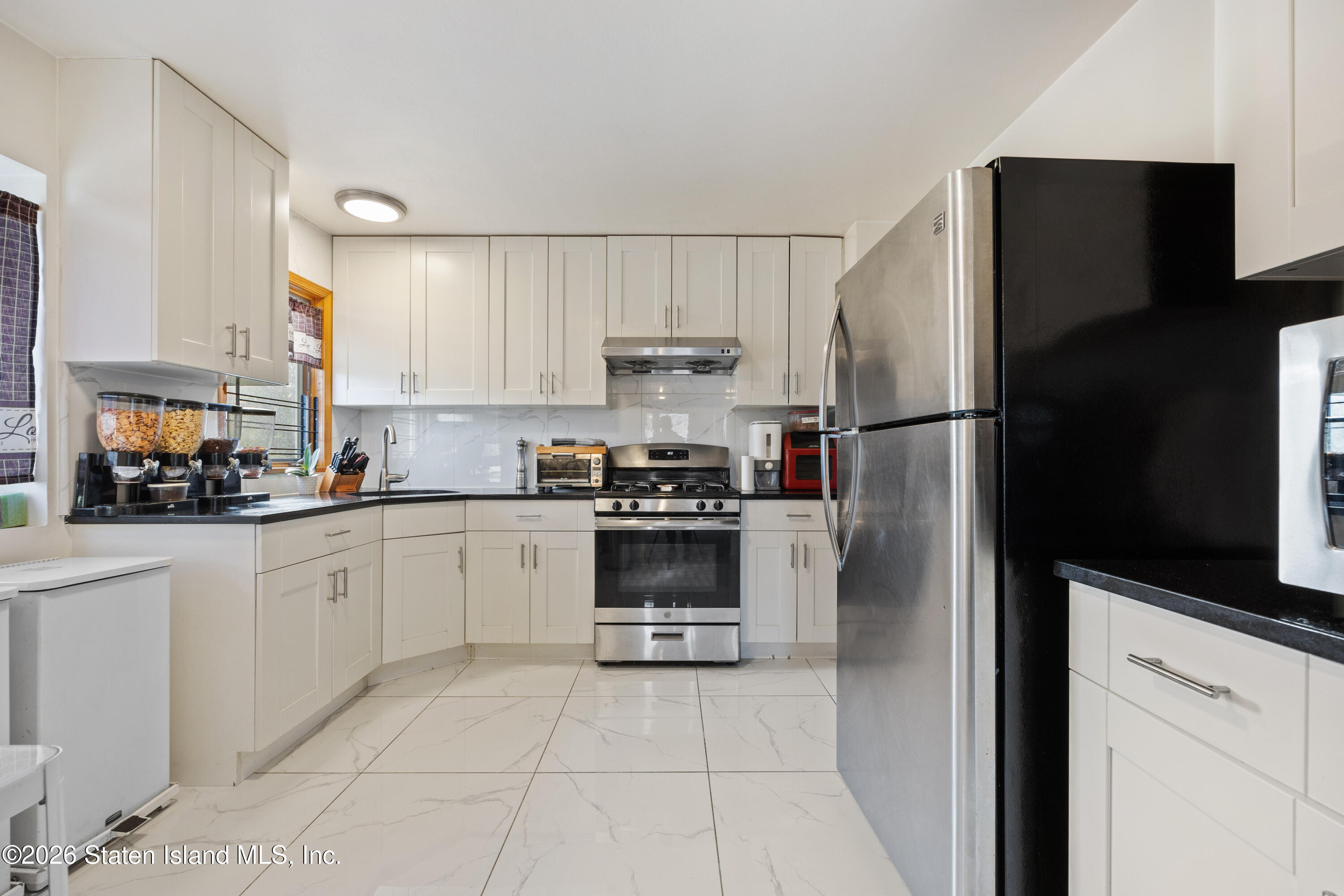 62 Bennett Place Staten Island, NY 10312 - Photo 18 of 34 a kitchen with a refrigerator sink and cabinets