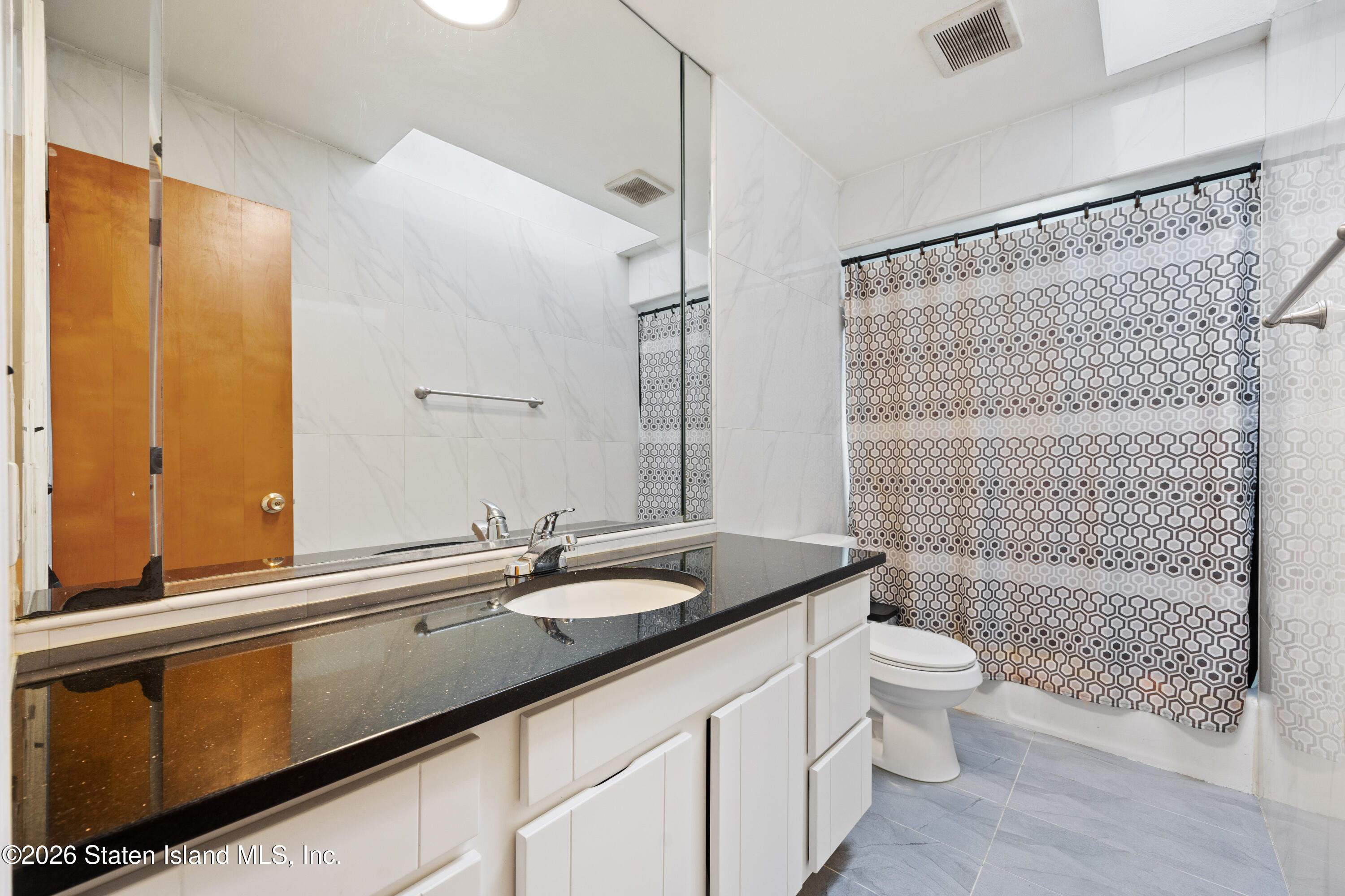 62 Bennett Place Staten Island, NY 10312 - Photo 20 of 34 a bathroom with a double vanity sink toilet and shower