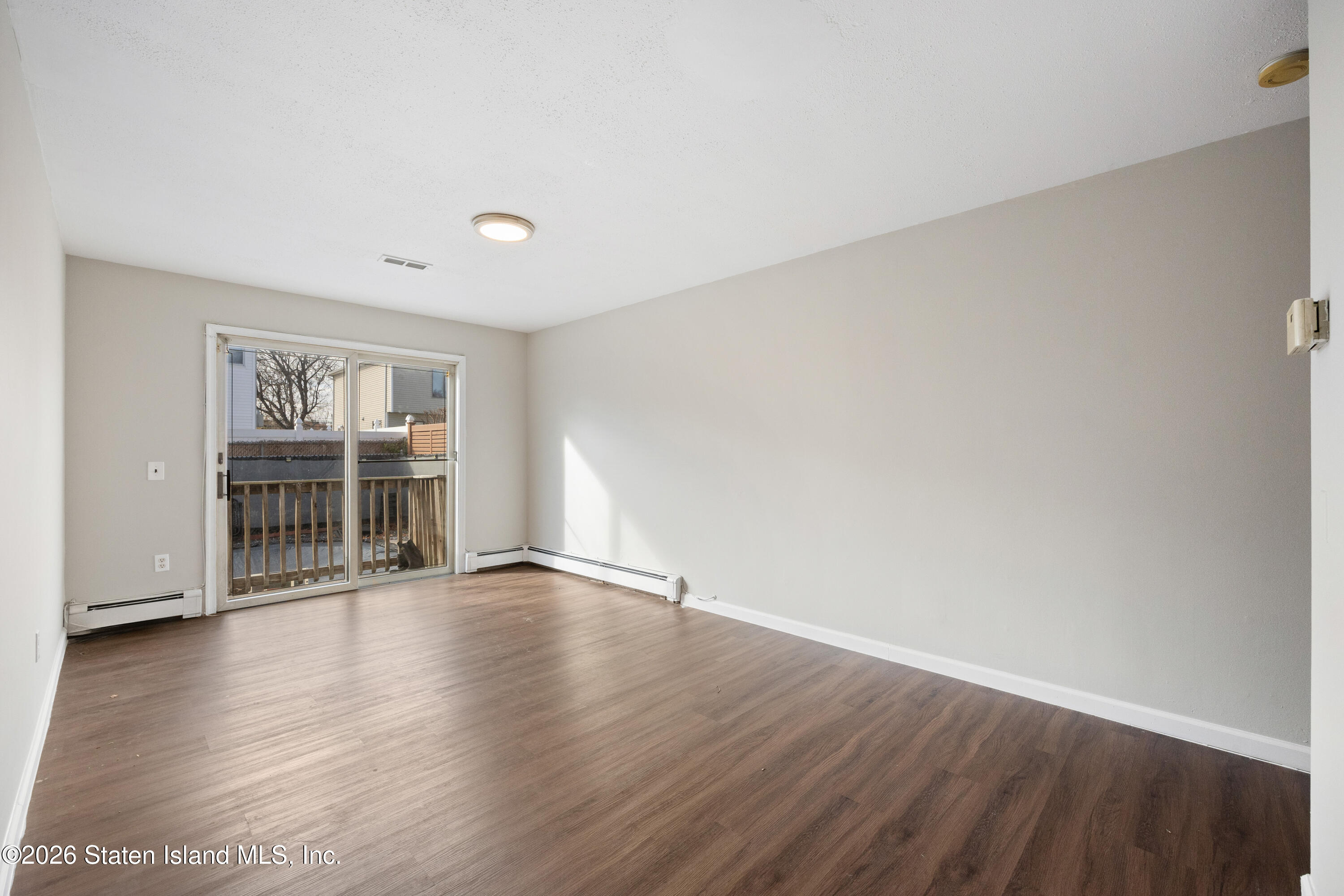 62 Bennett Place Staten Island, NY 10312 - Photo 7 of 34 a view of an empty room with wooden floor and a window