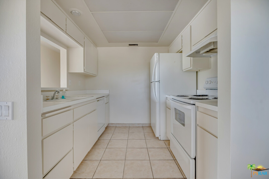 1111 East Ramon Road, Unit 69 Palm Springs, CA 92264 - Photo 4 of 20 a kitchen with white cabinets and white appliances