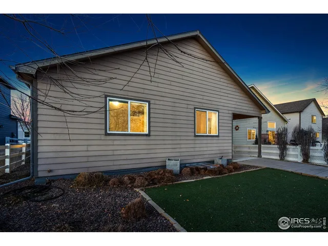 a view of an empty room with a window and kitchen view