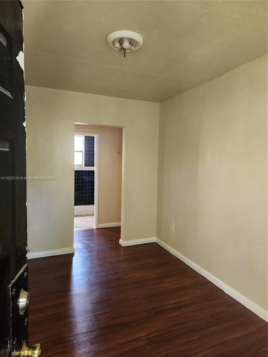 225 Northwest 17th Street Miami, FL 33136 - Photo 7 of 11 a view of a room with wooden floor and brick walls