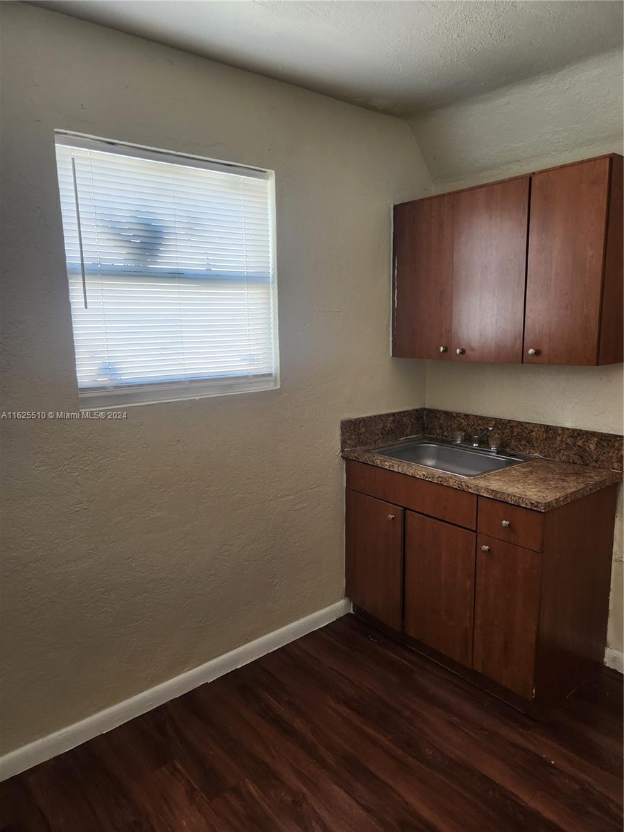 225 Northwest 17th Street Miami, FL 33136 - Photo 8 of 11 a view of an empty room with wooden floor and a window