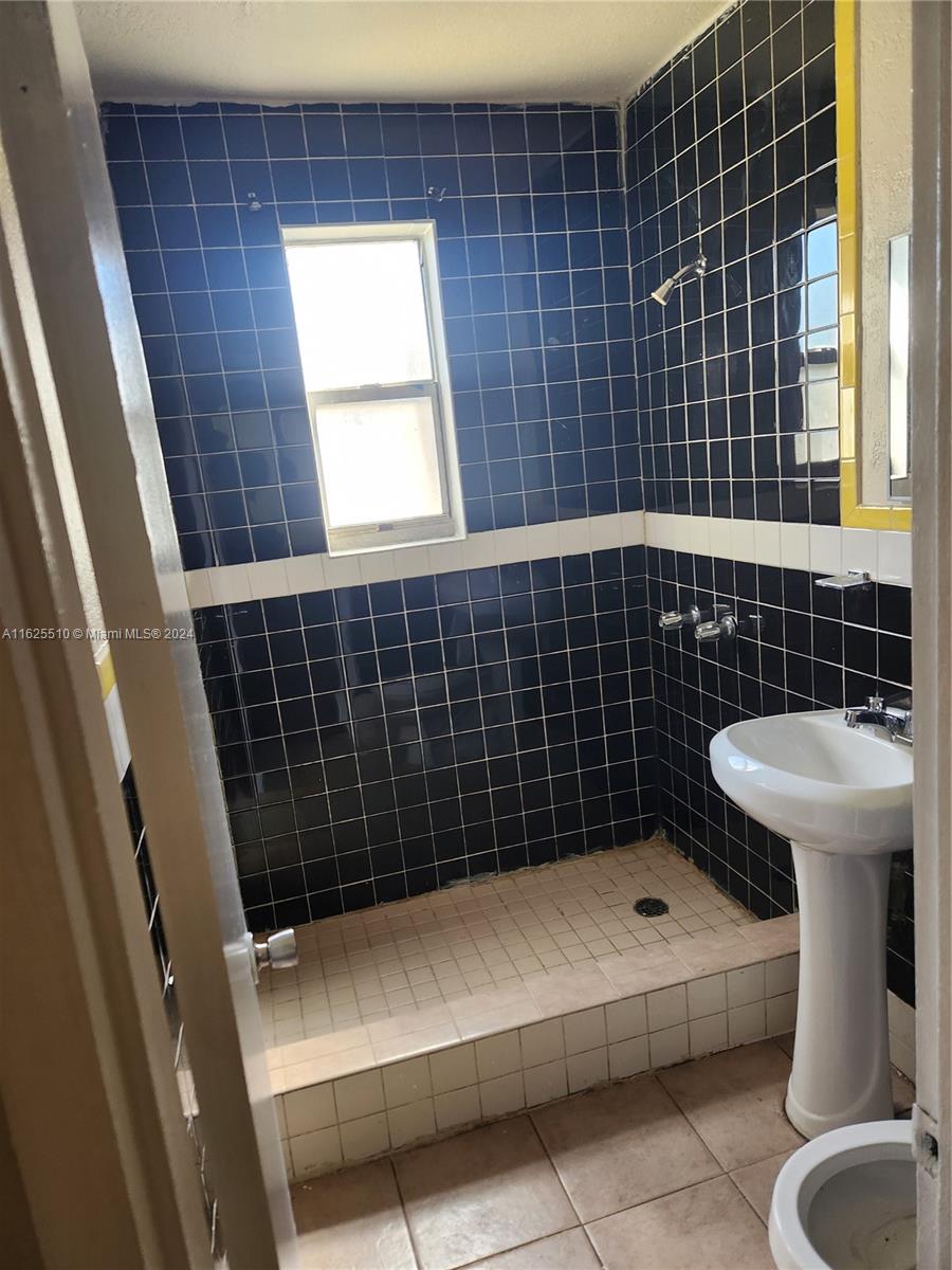 225 Northwest 17th Street Miami, FL 33136 - Photo 9 of 11 a bathroom with a sink toilet and window
