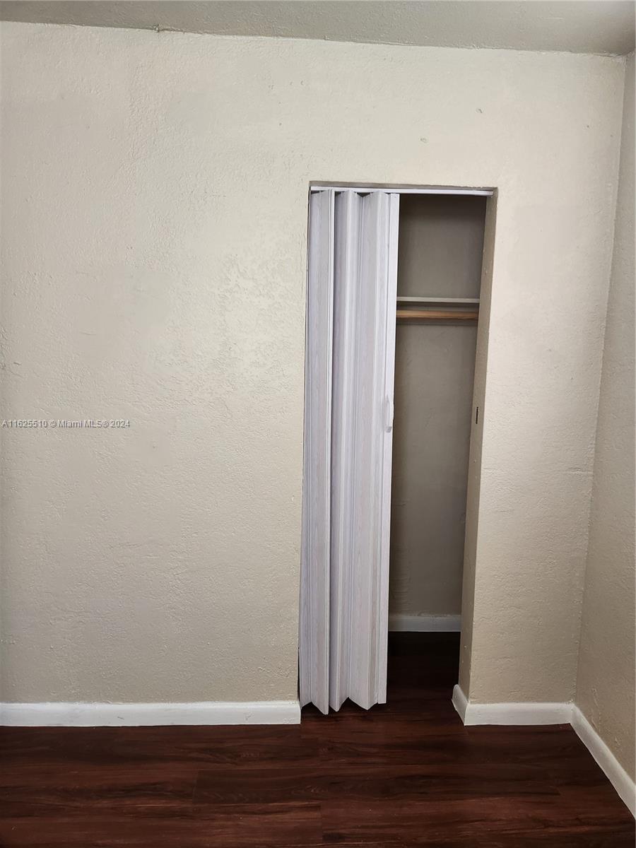 225 Northwest 17th Street Miami, FL 33136 - Photo 10 of 11 a view of empty room with wooden floor and white walls